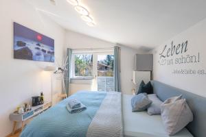 a bedroom with a blue bed and a window at Sonniges modernes ruhiges grosses Haus Garten Pool in Oberhaching