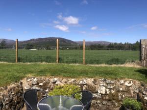 Ruthven House Holiday Cottages في كينغروس: طاولة وكراسي أمام سياج +8 صور