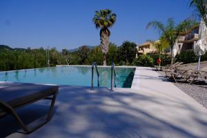 a swimming pool with a bench and a palm tree at The Seven Islands Deluxe Apartments in Gouvia +140 photos