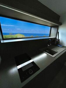 une salle de bain avec un lavabo et une grande fenêtre dans l'établissement Lovely place with free parking, à Corbara