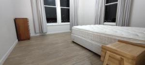 a bedroom with a bed and two windows at Newtown Camp de Luxe in Wellington