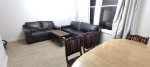 ウェリントンにあるNewtown Camp de Luxeの革張りのソファとテーブルのあるリビングルーム