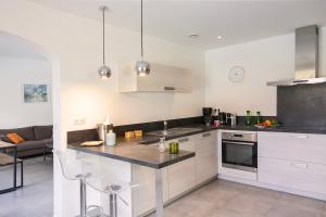 a kitchen with white cabinets and a counter top at Magnifique villa familiale avec piscine in Brando