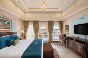 乌代浦Taj Fateh Prakash Palace Udaipur的一间带大床和电视的卧室