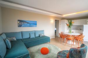 a living room with a blue couch and a table at Residence San Marco Suites&Apartments Alassio in Alassio