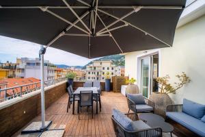 a balcony with a table and chairs and an umbrella at Residence San Marco Suites&Apartments Alassio in Alassio