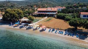 an aerial view of a beach with chairs and a building at Aigeiros Apartments & restaurant in Skala Mistegnon