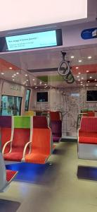 a train car with red and green seats on it at Métro - Sac à dos - Dodo Chez Léontine 2 chambres Parking Wifi in Colombes