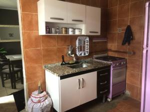 a kitchen with a sink and a stove at casinha da Sirlene in Nova Friburgo