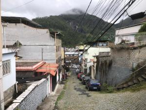 an alley with cars parked on a street between buildings at casinha da Sirlene in Nova Friburgo