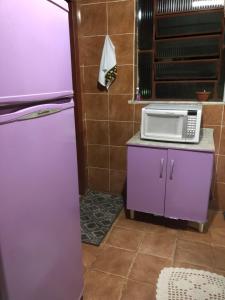a kitchen with a microwave on a counter next to a refrigerator at casinha da Sirlene in Nova Friburgo +3 photos