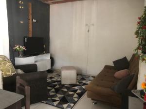 a living room with a couch and a tv at casinha da Sirlene in Nova Friburgo
