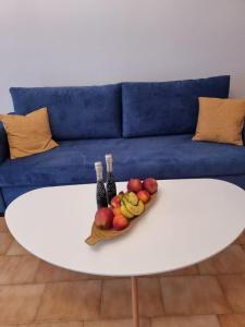 un bol de fruits sur une table blanche devant un canapé dans l'établissement Blue Waves, à Káto Ássos