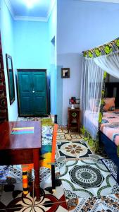 a room with a bed and a table and a floor at COCCOBELLO AFRICAN Village- in Nungwi