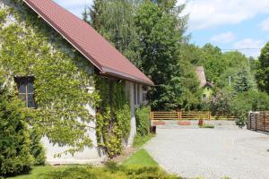 a building covered in ivy next to a house at Pensjonat EL-TAN in Złoty Stok