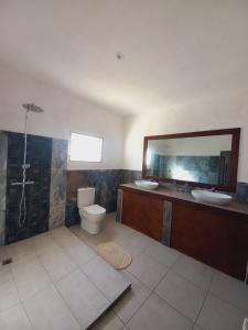 a bathroom with a sink and a toilet and a mirror at Prince Anakao in Anakao