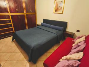 a bedroom with a bed and a red couch at Casa Magnolia in Galtellì