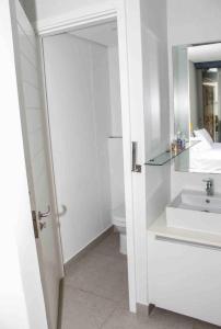 a white bathroom with a sink and a toilet at 2 Bedroom combo with pool at Ocean Dune, Sibaya in Umdloti