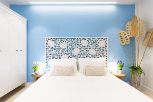 a bedroom with a white bed with a blue wall at La Tortuga Azul B in Puerto de la Cruz