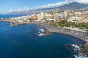 an aerial view of a beach with buildings and the ocean at La Tortuga Azul B in Puerto de la Cruz