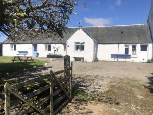 Ruthven House Holiday Cottages في كينغروس: بيت ابيض امامه سياج