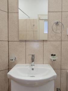 a bathroom with a white sink and a mirror at Gioula's Residence in Patitiri +63 photos