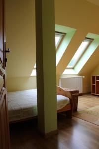 a bedroom with skylights and a bed in a attic at Pensjonat EL-TAN in Złoty Stok