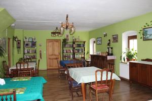 a dining room with green walls and wooden tables and chairs at Pensjonat EL-TAN in Złoty Stok