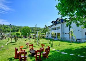 a park with a table and chairs and a building at Pensiunea CARLA in Sărata-Monteoru