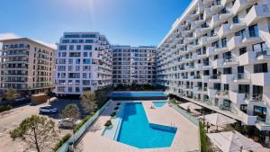 un complejo de apartamentos con piscina frente a un edificio en Sery Apartment Infinity Alz, en Mamaia Nord – Năvodari