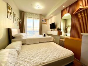 Casa Diana Pine Suites Tagaytay, Free Wi-Fi في تاجيتاي: غرفة نوم بها سريرين ومرآة +73 صورة