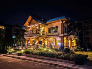 Casa Diana Pine Suites Tagaytay, Free Wi-Fi في تاجيتاي: منزل كبير في الليل مع أضواء