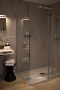 a shower with a glass door in a bathroom at La Maison du Gindreau in Saint-Médard