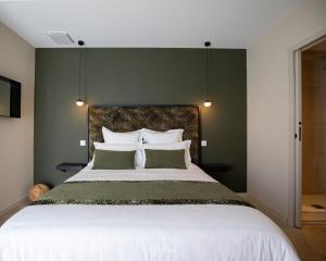 a bedroom with a large bed with green walls at La Maison du Gindreau in Saint-Médard