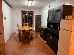 a kitchen with a table and a refrigerator at Basoan etxea in Sopuerta