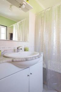 a white bathroom with a sink and a mirror at Casa Nossa in Lisbon
