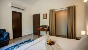 a bedroom with a bed and a chair and a desk at MiAmor by The StayCationer in Manesar