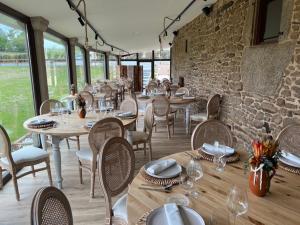 a restaurant with tables and chairs and a stone wall at A Casa do Pillado in Golada