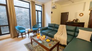 a living room with a green couch and a table at MiAmor by The StayCationer in Manesar