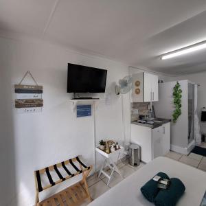 a living room with a table and a tv on the wall at Sleep Haven Self-Catering Accommodation - Nelspruit in Nelspruit +17 photos