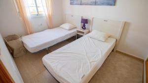 Dos camas en una habitación pequeña con ventana. en Lira 1013, en San Juan de los Terreros