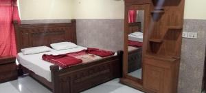 a small bedroom with a bed and a mirror at Buttkarahi Hotel And Restaurant in Dargai