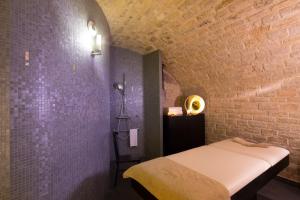 a bedroom with a bed and a brick wall at Hôtel du Triangle d'Or - Proche Madeleine in Paris