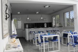 a dining room with tables and chairs and a kitchen at Badinomare in Terracina