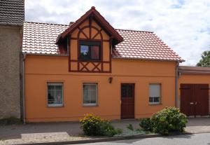 an orange house with a brown roof at Haus an der Stadtmauer in Lychen