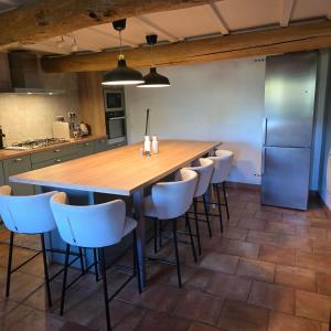 a kitchen with a large wooden table and chairs at Nid Panoramique in Massat +15 photos
