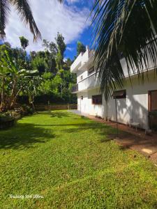 a building with a grass yard in front of it at Kingston Estate in Digana