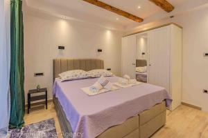 a bedroom with a large bed with towels on it at Toncica Sunny terrace with seaview and shaded BBQ area in Metajna