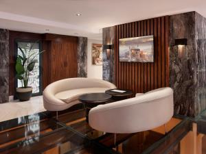 a living room with two white chairs and a table at Shining Star Hotel in Istanbul