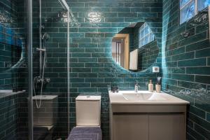 a blue tiled bathroom with a sink and a mirror at Herophile apartment close to airport & city center in Néa Alikarnassós +16 photos